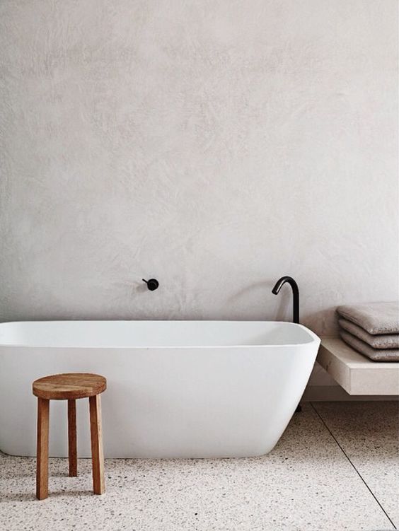 white concrete walls and light-colored terrazzo floors for a calming bathroom look