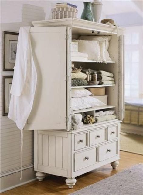 a vintage cupboard in cream for storing bathroom stuff and towels