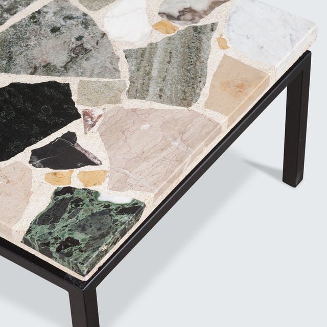 a coffee table with a terrazzo top inlaid with marble, quartz, and granite