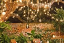 27 lots of string lights turn this backyard into a magical space