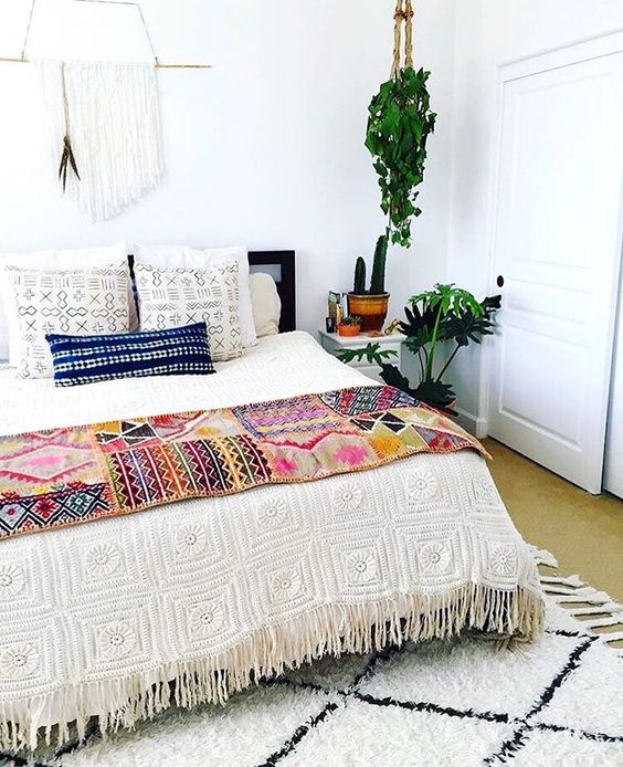 a crochet fringe bedspread, printed pillow covers and a bold boho throw