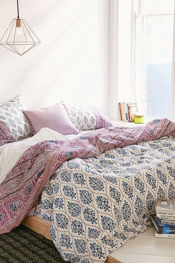 blue, mauve and white printed bedding and tassel pillows