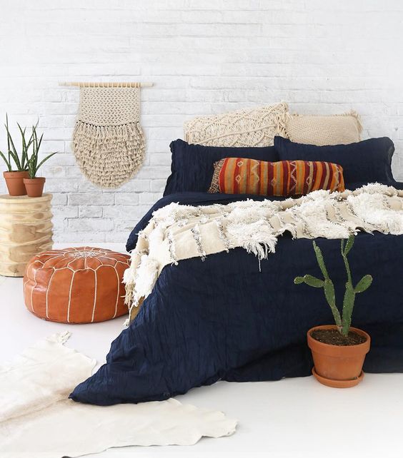 textural navy bedding with white crochet pillows and a fringe blanket