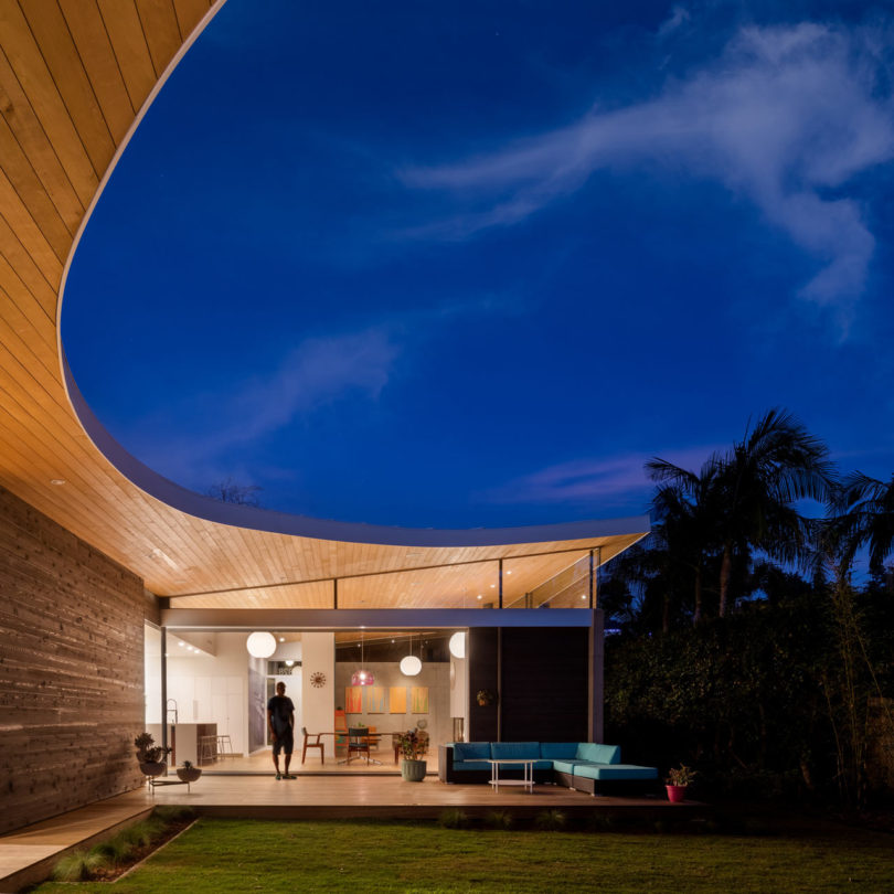 The house is made of three pavilions under one sloping roof, which extends outside to make the house merge with nature