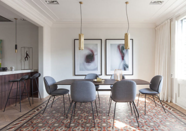 The dining zone united with the living room is defined with two modern brass pendant lamps