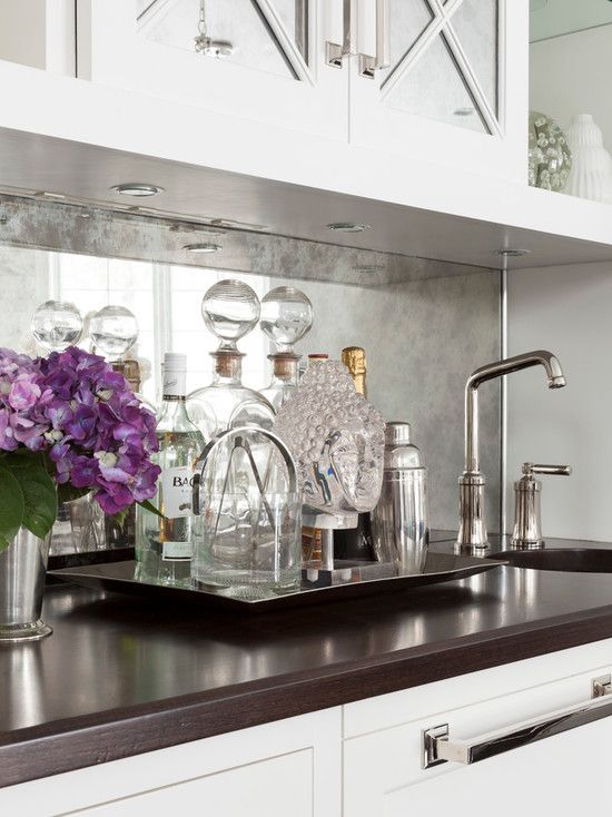 a silver faded mirror backsplash in easily maintainable and looks nice with white cabinets