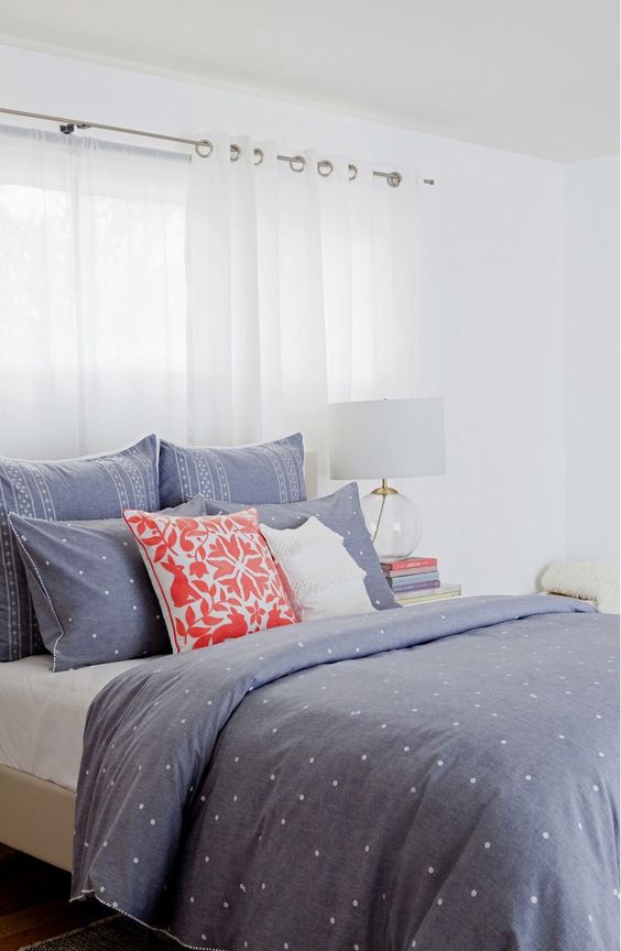 blue and white polka dot bedding set with other prints and two acent pillows in white and coral