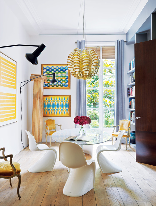 The dining room is accentuated with sunny yellow and blue, look how Pantone chairs fit the glass top dining table   this is a gorgeous idea