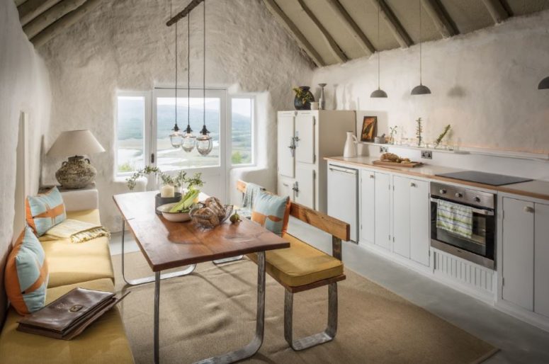The kitchen is a line of cabinets by the wall, and the dining zone offers amazing views on the landscape