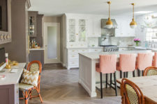04 The kitchen island is large and doubles as a breakfast zone, the space is spruced up with peachy chairs