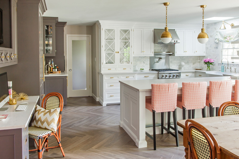 The kitchen island is large and doubles as a breakfast zone, the space is spruced up with peachy chairs