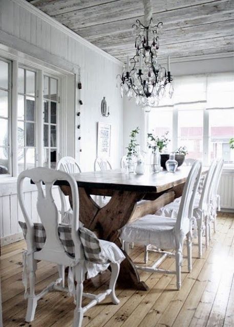 a white shabby chic dining space with a wooden trestle table
