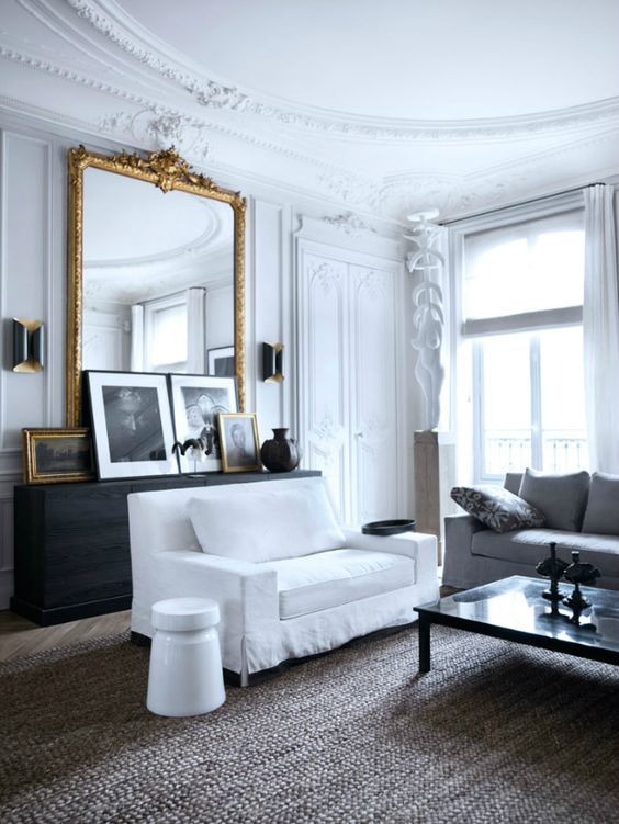 an antique French framed mirror adds chic and beauty to this living room