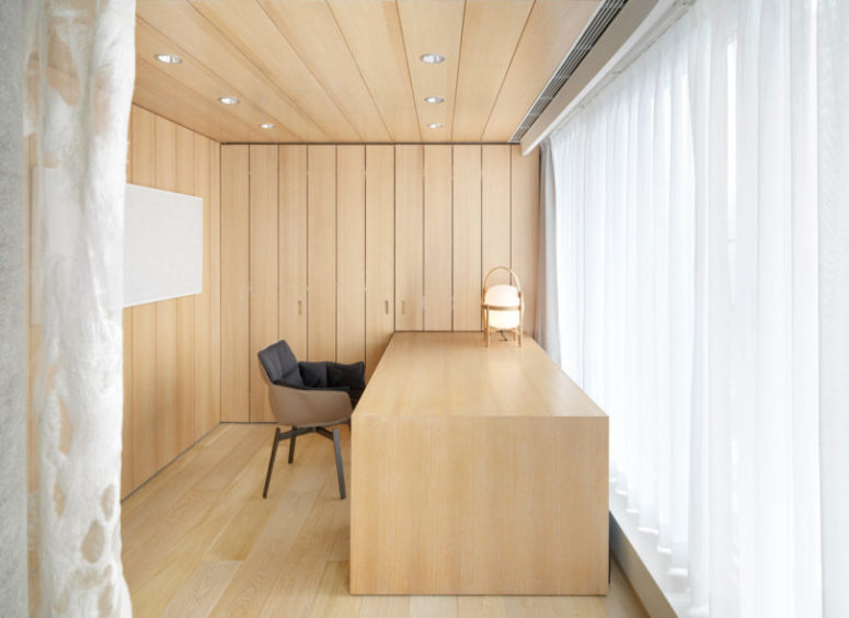 The home office is very laconic, all clad with wood and with a desk of the same type of wood