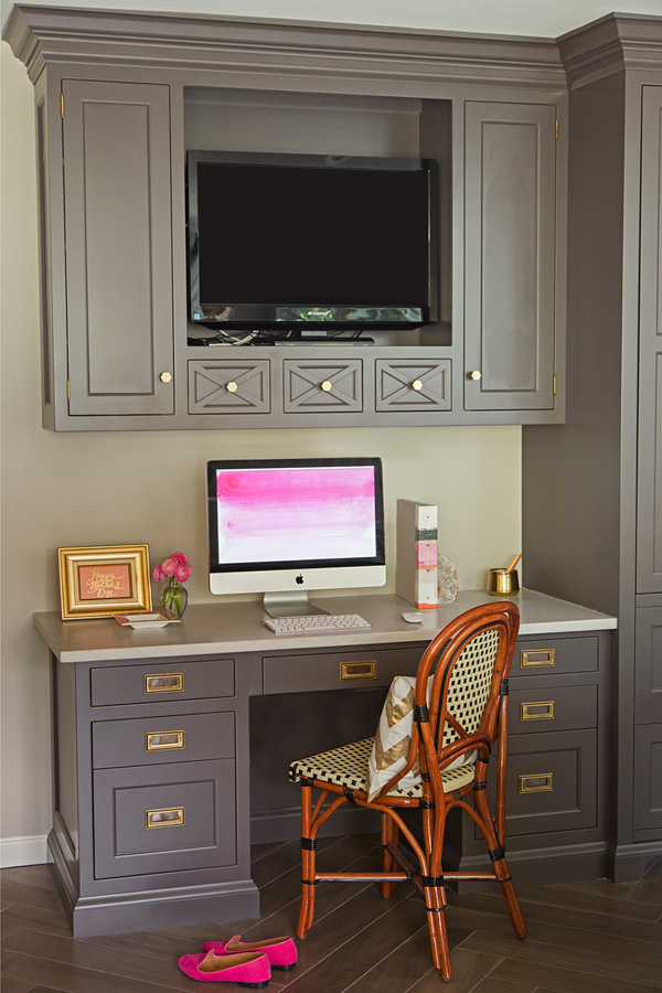 The home office is visually divided from the kitchen with a different shade of cabinets and more traditional design