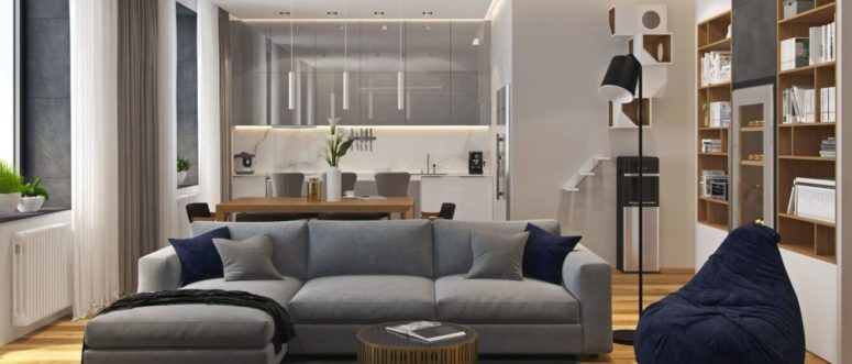 The living space features a large grey sofa with navy pillows, and the kitchen comes in the same shade of grey, too