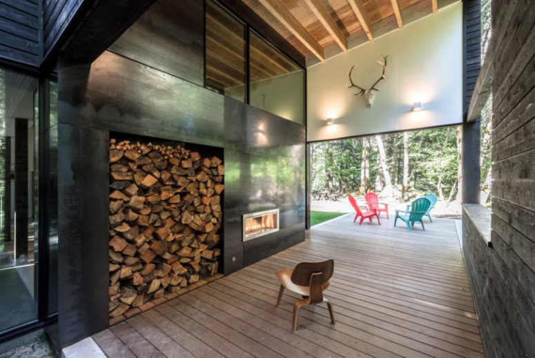 There's a covered outdoor veranda that features a fireplace with firewood storage and a sitting space