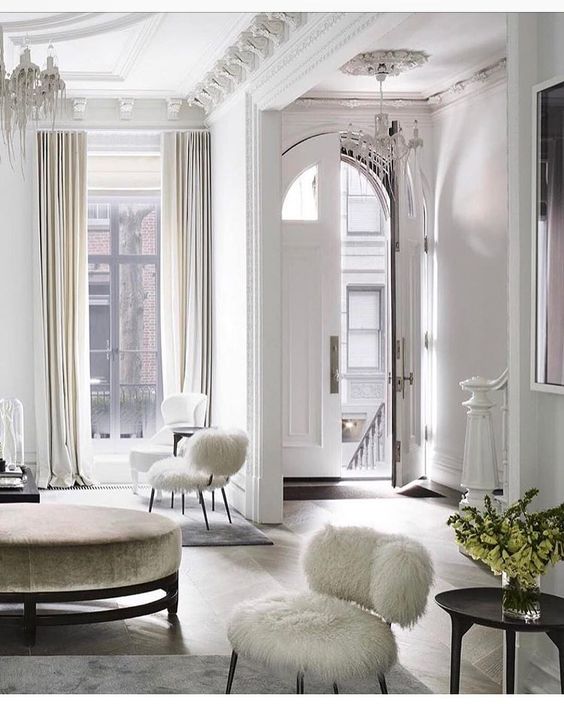 fur chairs and a velvet ottoman add chic to the space and look cozy