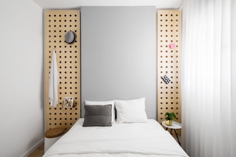 The master bedroom is small and simple, with cool wooden panels for storage and mismatching nightstands