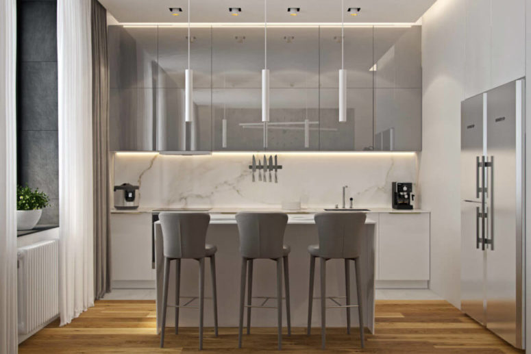 White marble, white cabinets and light grey lit up cabinets and chairs look soothing and heavenly