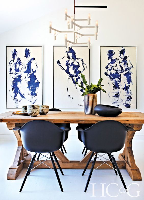 a gorgeous modern dining space with a trestle wooden table and black chairs