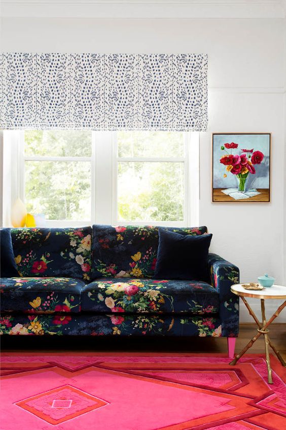 the colorful room in pink and red is made calmer with a navy floral print sofa
