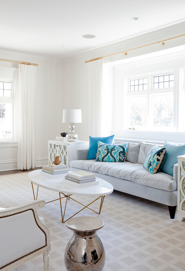 The living room is neutral, with blue pillows and eclectic furniture