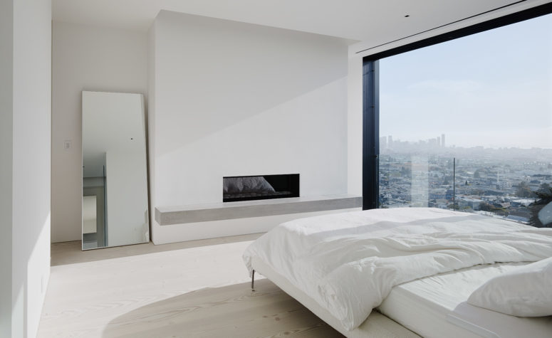 The master bedroom features a glazed wall with jaw-dropping views, a built-in fireplace and a large bed