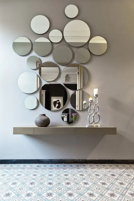 a circle wall mirror arrangement looks cool and modern, such an unusual decor idea