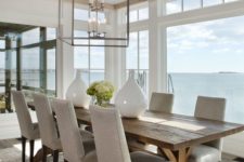 a coastal dining space with a view looks cozier with a rustic dining table