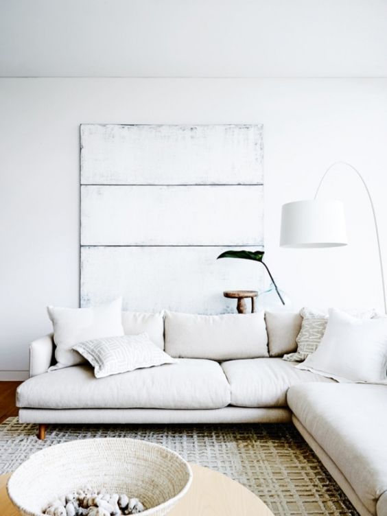 a whitewashed wooden board and a rope basket add texture to the living room