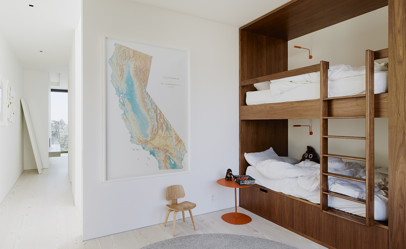 The kids' bedroom has a wooden bunk bed, a map on the wall and some small accessories
