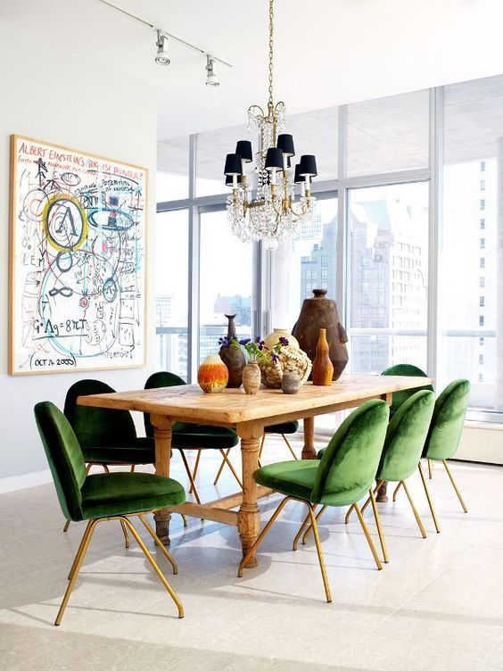 a dining space is enlivened and spruced up with emerald velvet dining chairs with brass legs