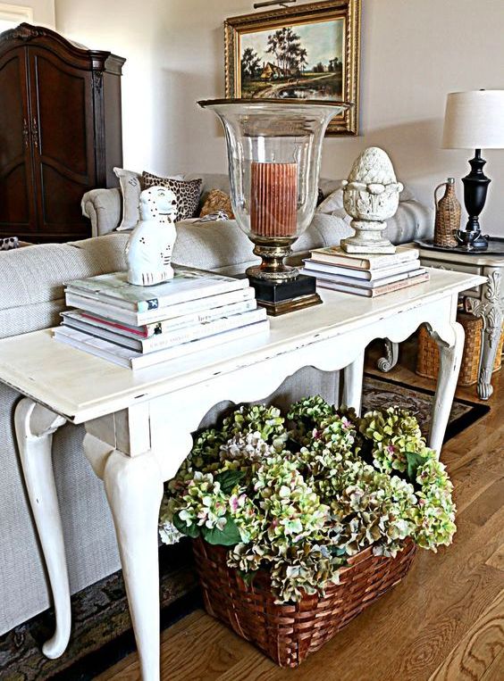 a traditional living room with a white vintage desk used as a console table
