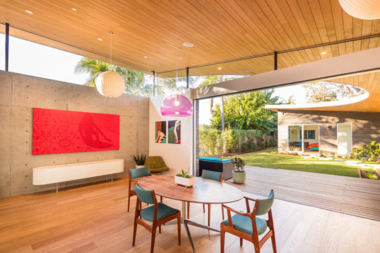 The dining space features mid-century modern furniture and bright artworks plus skylights