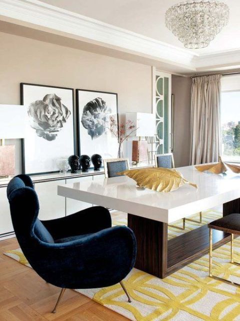A mid century modern dining space in neutrals with yellow accents and a chic comfy navy velvet armchair