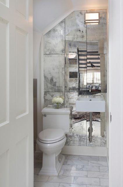 a faded mirror wall can make a tiny powder room look bigger and more stylish at the same time