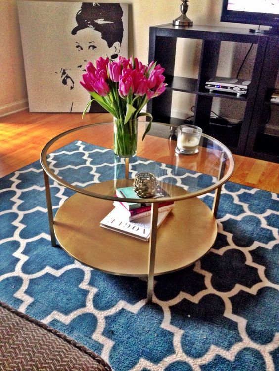 an elegant round copper and light wood and glass table with two tabletops for storage for a girlish space