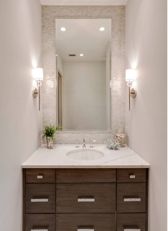 small mother of pearl tiles accentuate the sink zone and spruce up a neutral bathroom