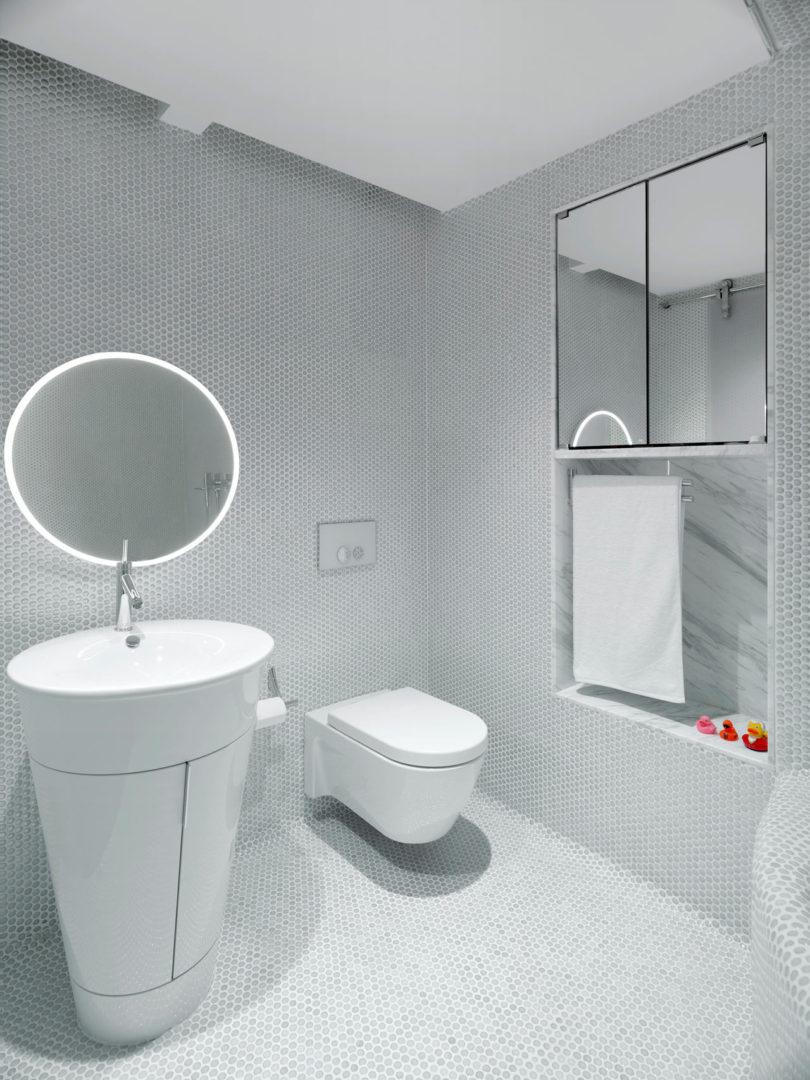 The second bathroom is clad with hex penny tiles and with modern appliances