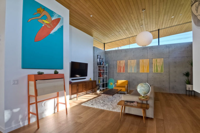 The walls are done of concrete, and the floors and ceilings are wooden, so bright artworks stand out in such spaces