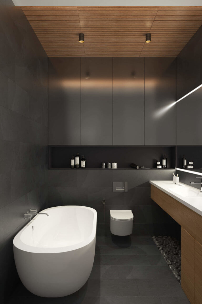 The master bathroom is done in matte charcoal grey, with pebbles for a spa feel and a free-standing bathtub
