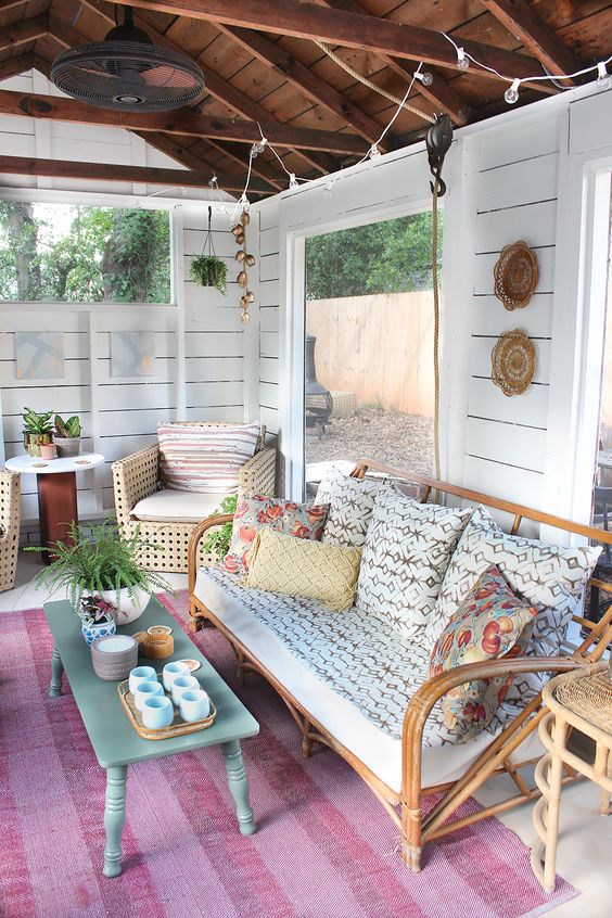 a rustic and vintage living room with panoramic windows, rattan furniture and boho decorations