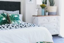 12 tropical leaf print pillows and a matching ottoman for a summer bedroom