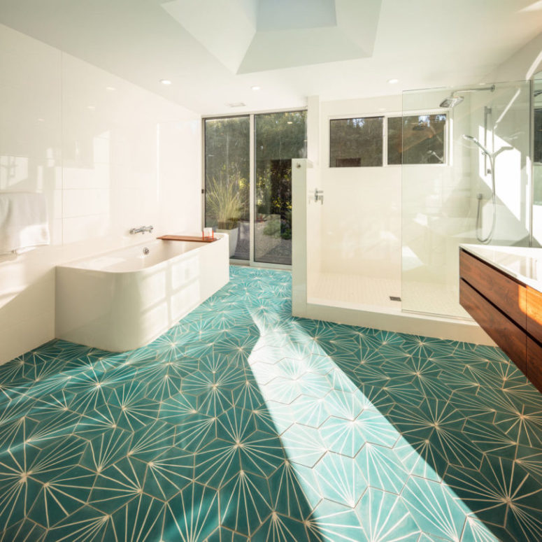 The bathroom boasts of green geo tiles and a gorgeous view, plus it can be opened to outdoors