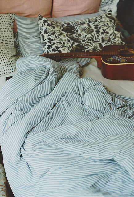 a blue striped bedding set and some accent botanical print pillows