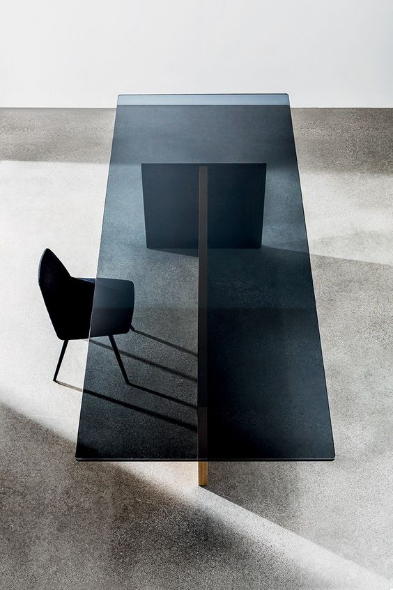 a minimalist glass and wood table with a smoked glass tabletop looks chic and edgy