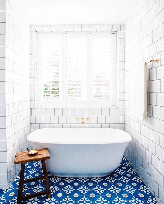 blue patterned tiles on the floor and white subway tiles for a gorgeous bathroom