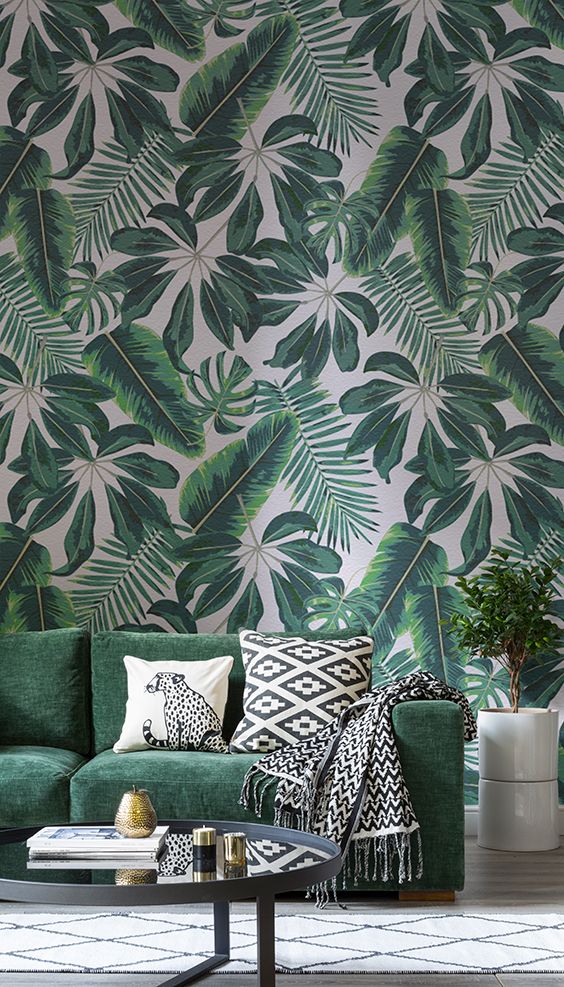 mixed tropical leaf wallpaper and a matching emerald sofa are ideal for a summer living room