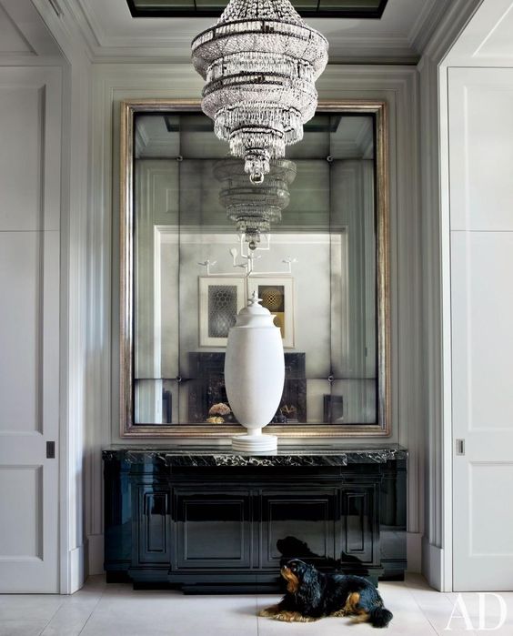 oversized mirror in a metallic frame with a large vintage chandelier look exquisite and adorable